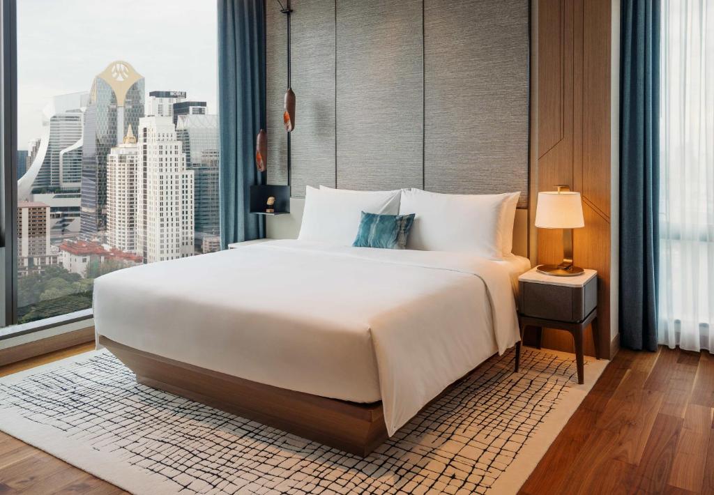 A stylishly decorated room at Kimpton Maa-Lai Bangkok, with lush green views of Lumpini Park.