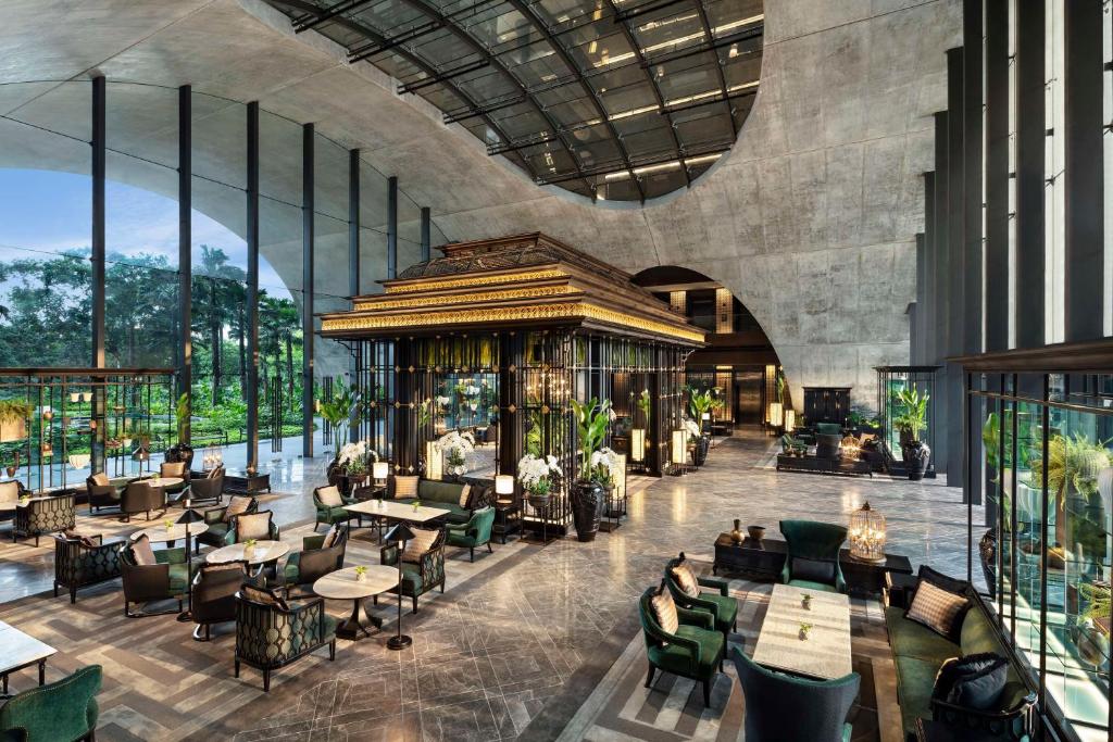 The grand, green-filled lobby of Sindhorn Kempinski, embodying the 'living in a park' concept.