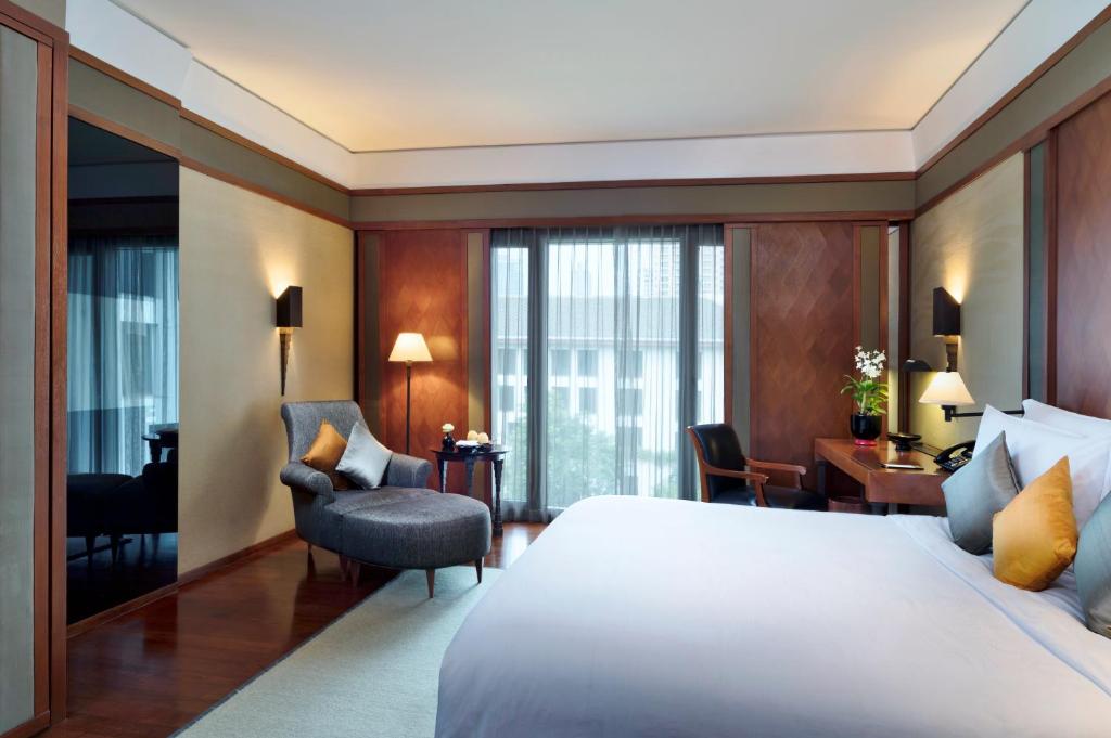 The tranquil courtyard of The Sukhothai Bangkok, featuring chedi-like stupas and serene lotus ponds.