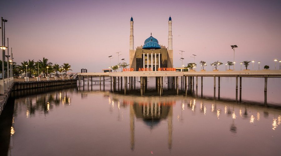 [Reflections of the three-story Amirul Mukminin Mosque on the water, a testament to the architectural wonders in this Indonesia travel guide.]