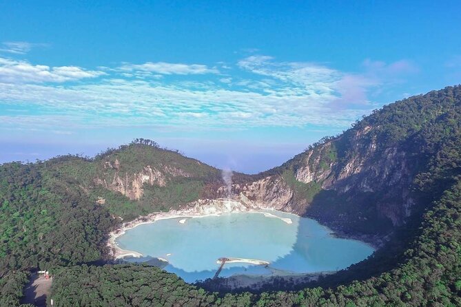 [A wider view of the acidic Kawah Putih lake, its color shifting with the light, a captivating natural wonder in this Indonesia travel guide.]
