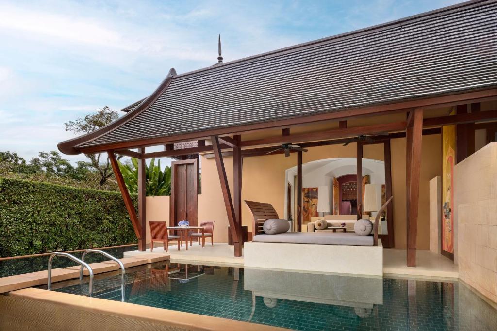 An opulent bathroom in a villa at Phulay Bay, featuring a large standalone bathtub and ornate, colorful Thai wall paintings.