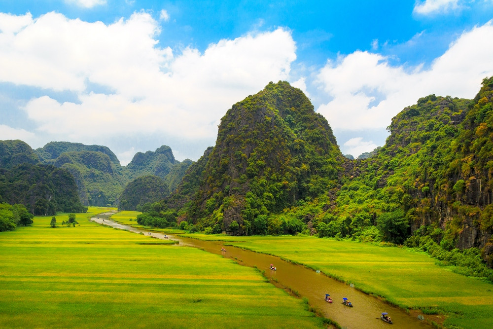 [The dramatic limestone karsts of Ninh Binh under a brilliant blue sky, a picturesque scene from our Vietnam travel guide.]