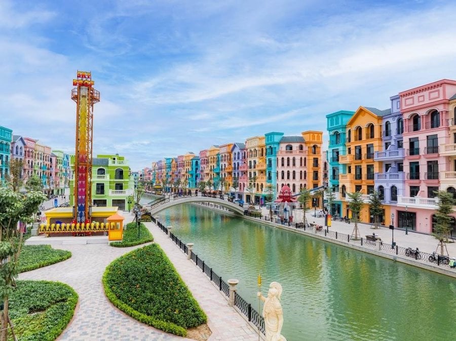 [A view of the brightly colored buildings lining the man-made canal at Mega Grand World, featured in our Vietnam travel guide.]