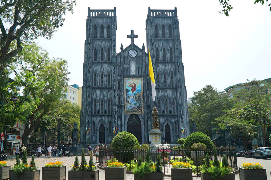 [A dramatic, angled view of the grey stone facade of St. Joseph Cathedral against a clear sky.]