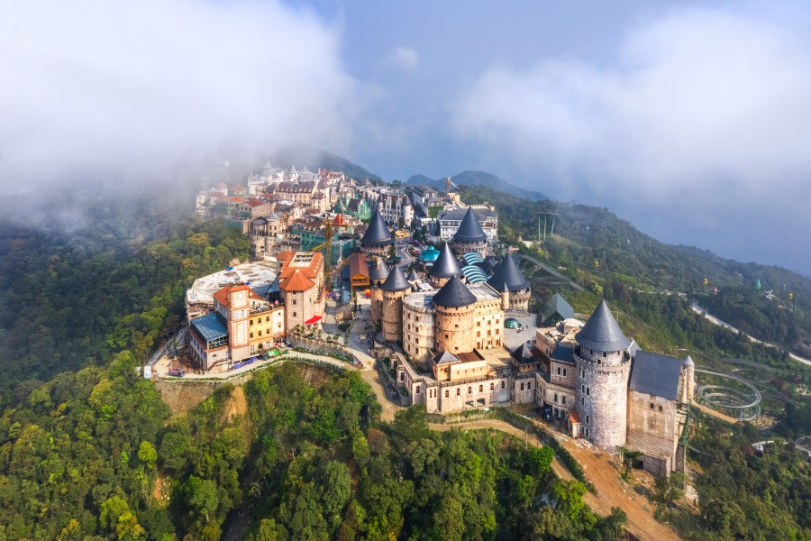 [A misty, aerial view of a European-style castle complex within Ocean Park 3 near Hanoi.]