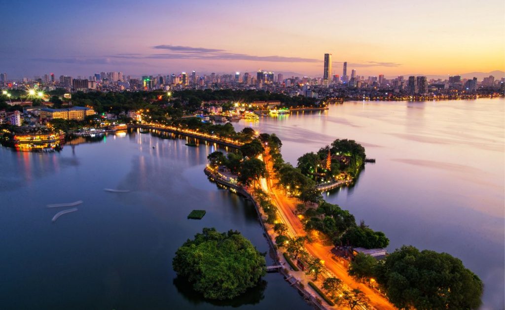 [A serene sunset over Hoan Kiem Lake and the iconic Turtle Tower in Hanoi, one of the essential things to do in Vietnam's capital.]