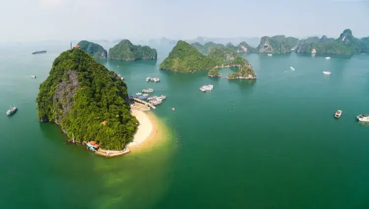 [Traditional junk boats dot the waters around Titop Island, a classic scene from our Vietnam travel guide.]