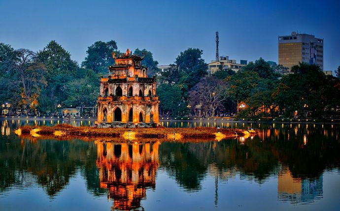 [The beautifully illuminated Ngoc Son Temple on Hoan Kiem Lake at night, a captivating landmark in Hanoi.]