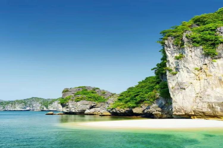 [A small, pristine beach nestled among the limestone karsts of Ha Long Bay, near Luon Cave.]