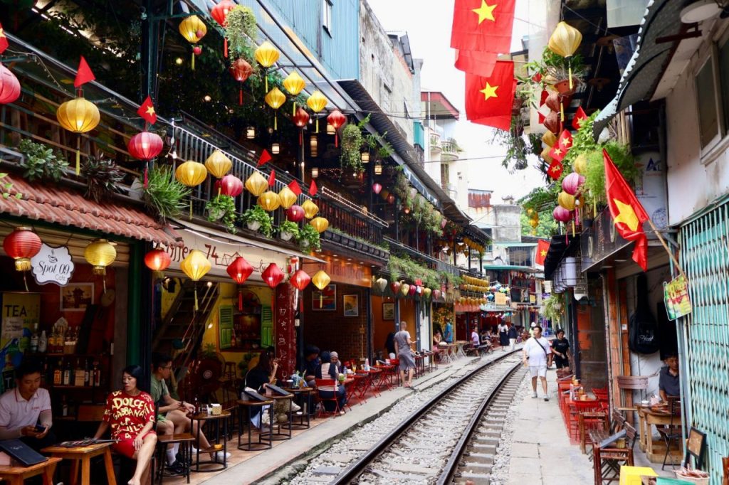 [Hanoi's Train Street adorned with colorful lanterns, creating a magical evening ambiance for visitors.]